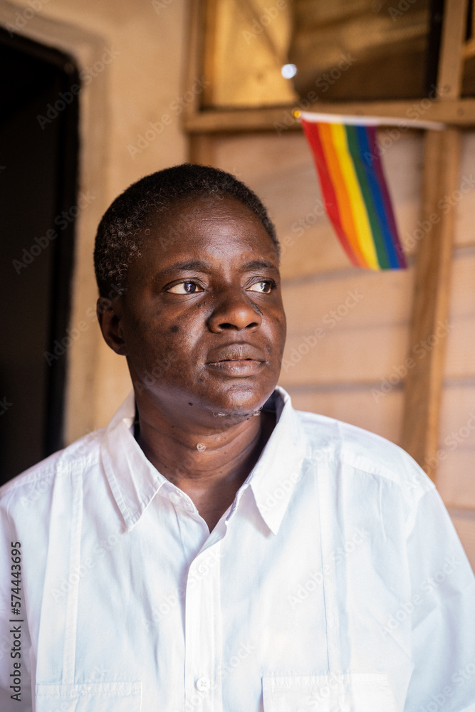 Portrait of a queer masculine woman in front of a
rainbow flag Portrait of a queer masculine woman in front of a
rainbow flag