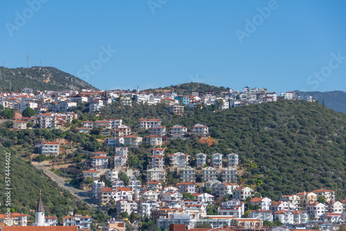Fototapeta Naklejka Na Ścianę i Meble -  Majestic panoramic view of seaside resort city of Kas in Turkey. Hillside with traditional houses in the city, Villas and hotels with red roofs are open for tourists.