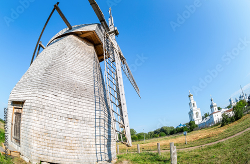 Old wooden windmill against the St. George (Yuriev) Orthodox monastery in Veliky Novgorod, Russia photo