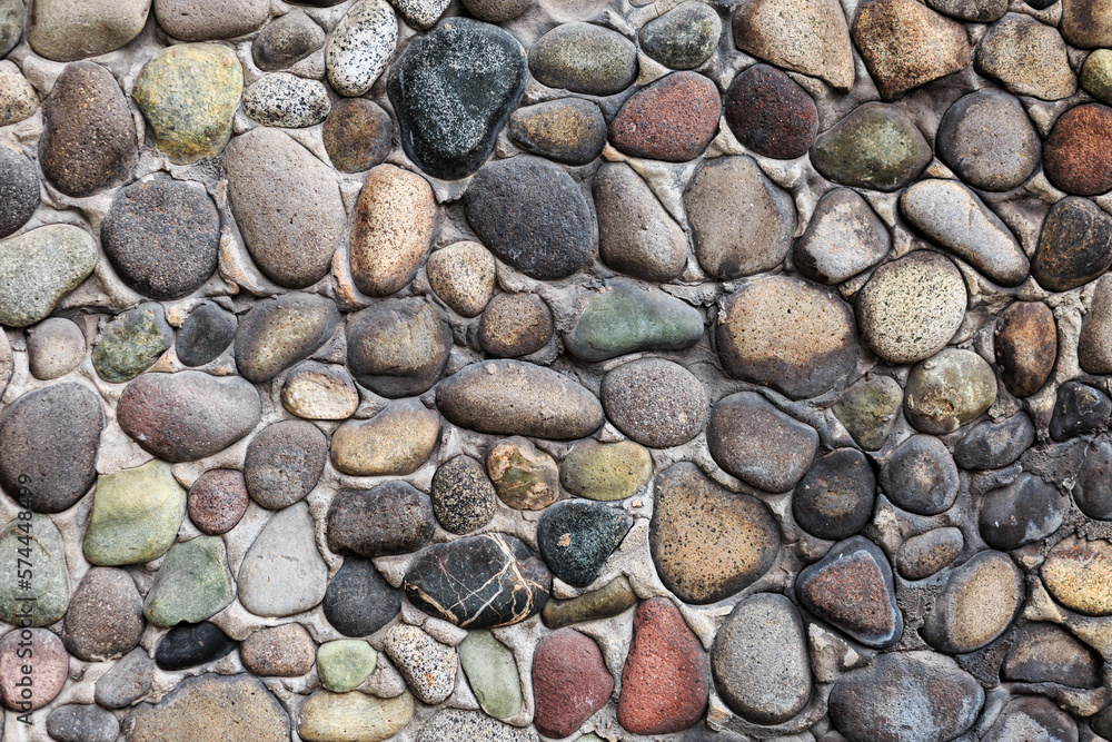 Textured stone wall with multicolored and different shaped stones. Textured stone wall with multicolored and different shaped stones.