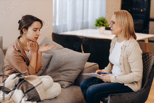 Sad frustrated woman talking in a session with a psychotherapist about her problems