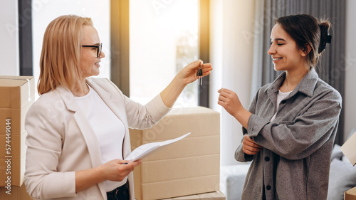 Realtor agent giving a key of apartment to new owner after signed lease agreement.