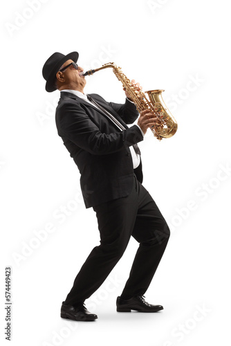Full length profile shot of a mature elegant musician playing a sax