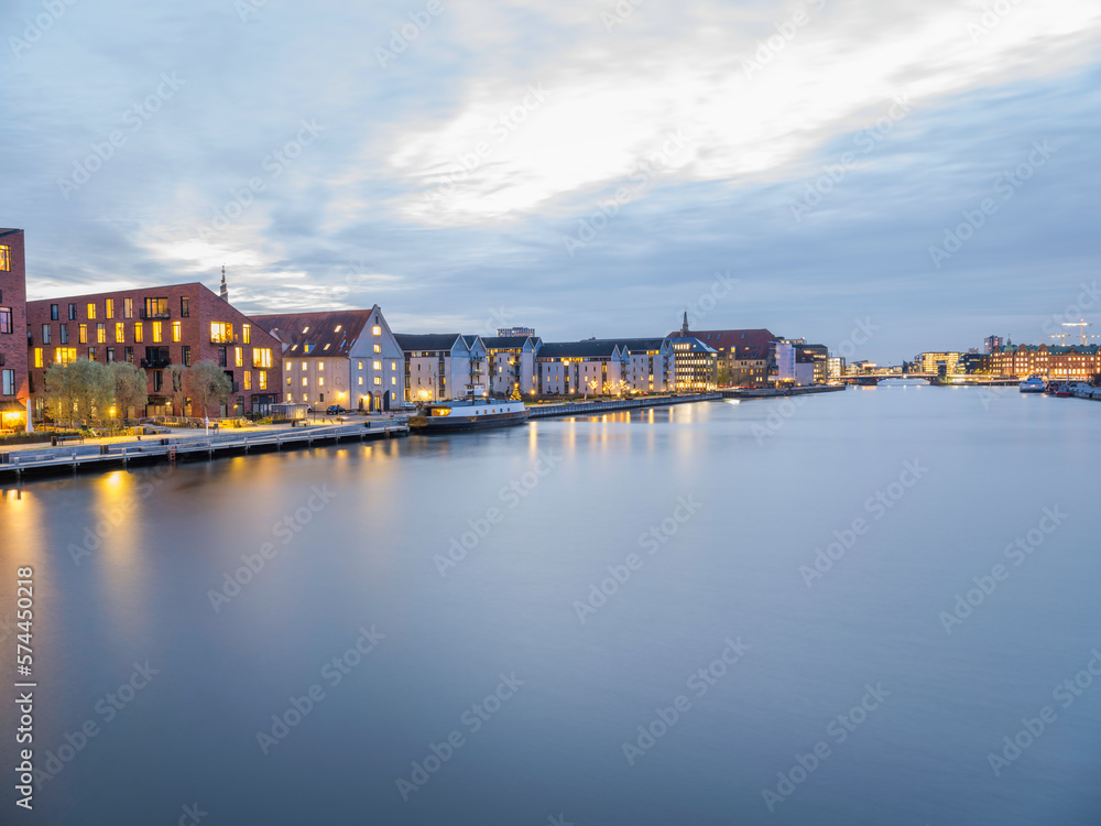 Buildings lit up on  Christianshavns canal after sunset, Copenhagen, Denmark