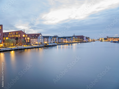Buildings lit up on  Christianshavns canal after sunset, Copenhagen, Denmark