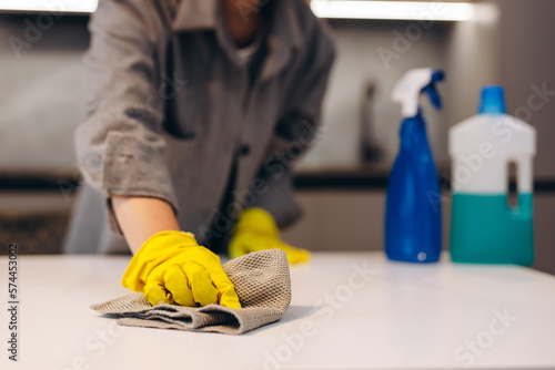 Cleaning hygiene, young maid woman, girl hand in using a water sprayer bottle to wipe clean, use rag wiping to dust on white marble table in. Housekeeping cleanup, cleaner.