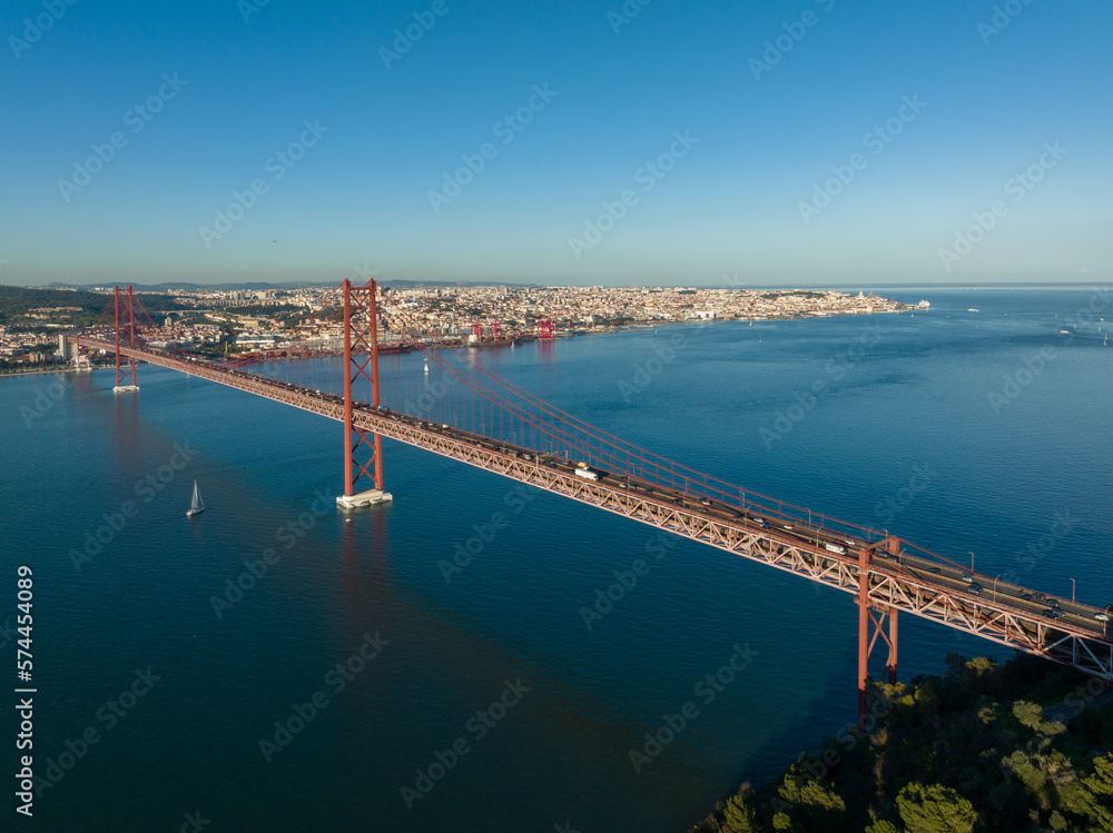 The 25 April bridge (Ponte 25 de Abril) located in Lisbon, Portugal, crossing the Targus river. Drone.
