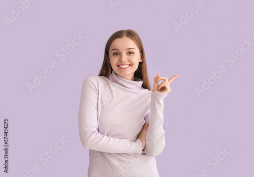 Young woman in sweater poin...