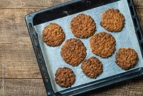 Delicious oatmeal cookies with walnuts on baking sheet, closeup, top view