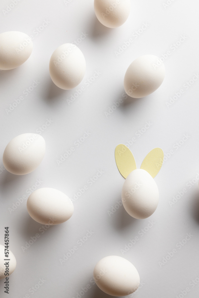 Naklejka premium Image of white easter eggs with bunny ears and copy space on white background