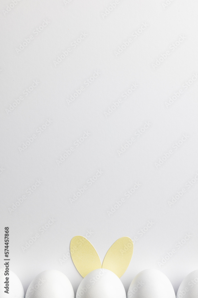 Obraz premium Image of row of white easter eggs with bunny ears and copy space on white background