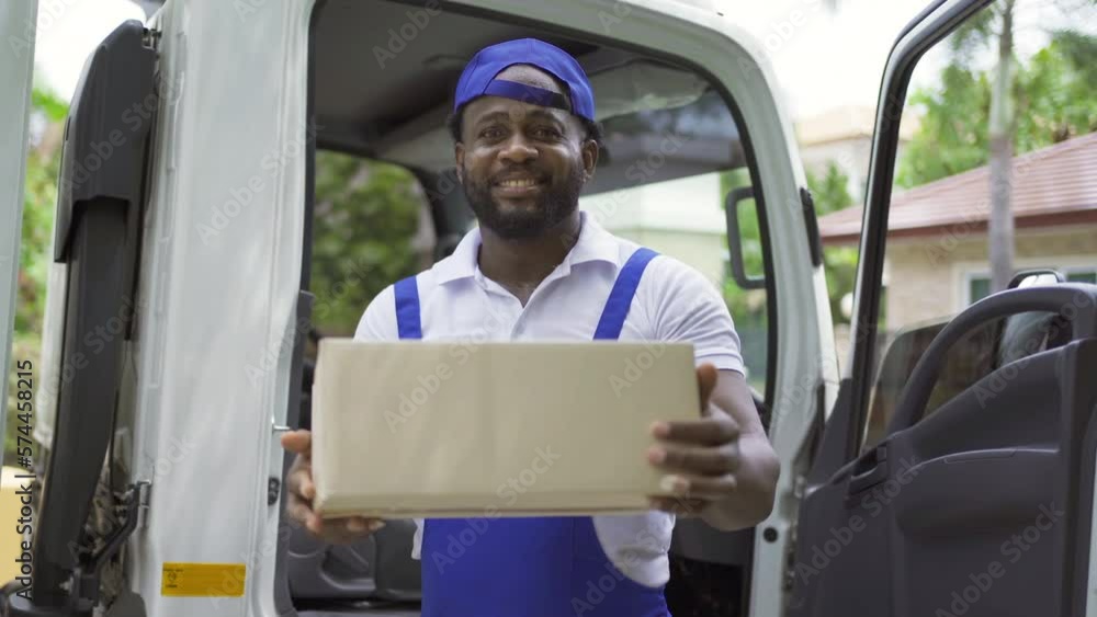 Black employee worker with a truck car moving house for customers, delivering boxes with uniform. Vehicle transportation. Shipping and packaging business occupation service company. People lifestyle. Black employee worker with a truck car moving house for customers, delivering boxes with uniform. Vehicle transportation. Shipping and packaging business occupation service company. People lifestyle.