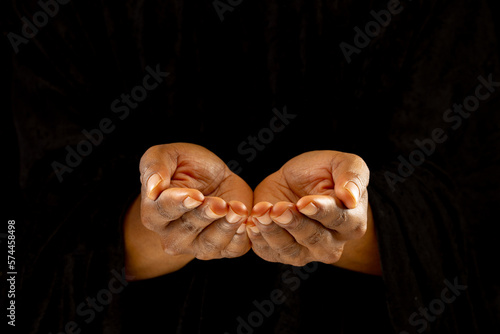 Image of close up of hands of african american woman praying