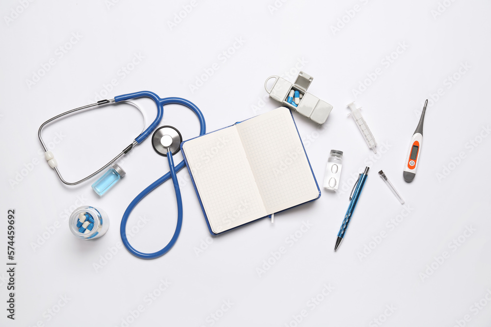 Blank notebook with medical supplies on white background. World Health Day - obrazy, fototapety, plakaty 