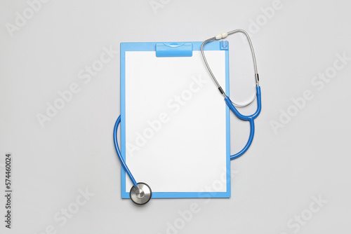 Blank clipboard with stethoscope on grey background. World Health Day photo