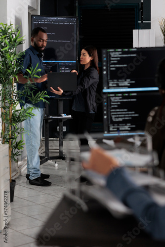 Plakat w ramie Diverse team of software programmers analyzing html code on wall screen tv, using digital gadget and working with artficial intelligence. Coders parsing cloud computing project with big data.