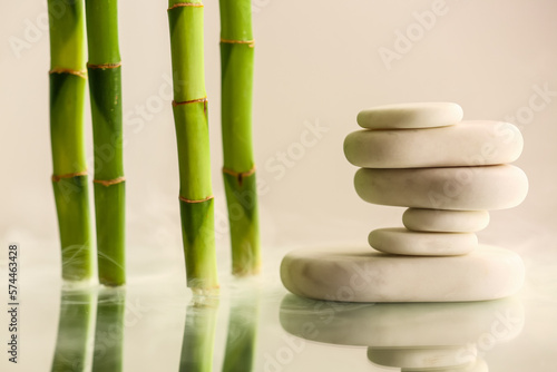 Stack of spa stones and bamboo on light background