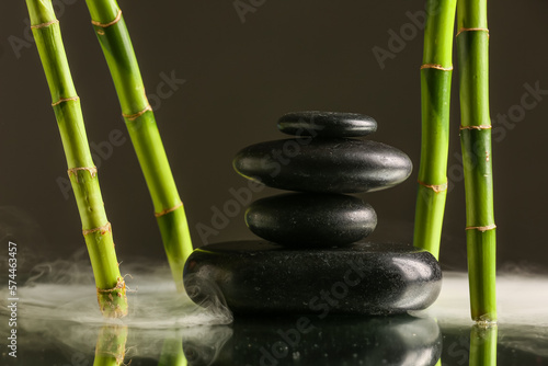 Stack of spa stones and bamboo on black background