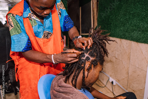 Canvas-taulu A young queer masculine woman retwisting her dreadlocks
