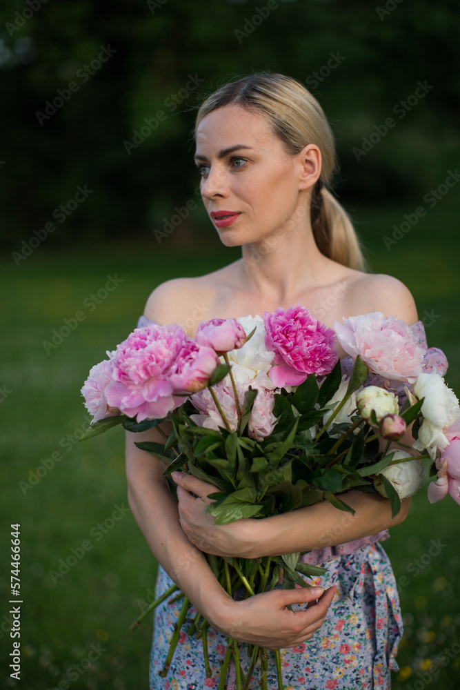 beautiful blonde woman with beautiful bouquet of peonies.