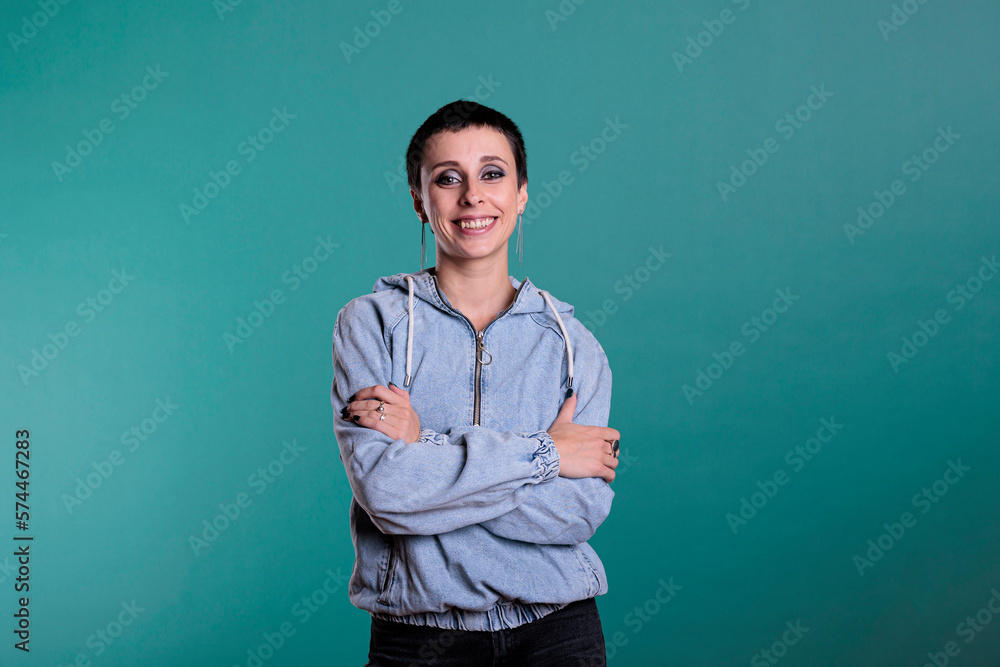 Portrait of smiling fashionable model looking at camera during studio shot posing confident while standing over isolated background. Cheerful happy woman with short hair and gorgeous makeup Portrait of smiling fashionable model looking at camera during studio shot posing confident while standing over isolated background. Cheerful happy woman with short hair and gorgeous makeup