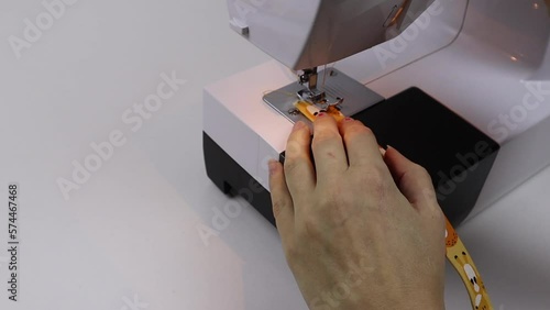 Hobby sewing on a sewing machine. The tailor cuts out the details of the product and sews. The girl is engaged in needlework, creativity.