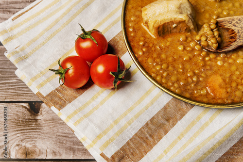 Still life with a plate of lentils on a new kitchen towel and with some ripe cherry tomatoes photo