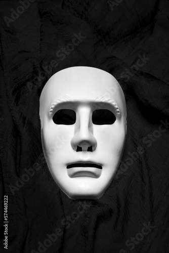 Expressionless white masks on a black cloth