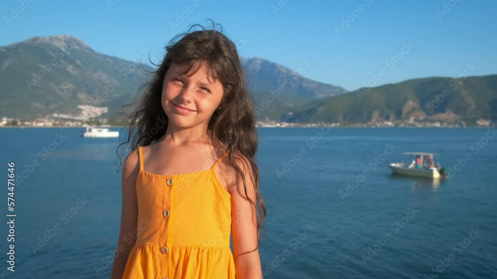 Child warm up on piers. A pretty little girl admire the breeze on her skin and warming up on wooden pier by the sea. Child warm up on piers. A pretty little girl admire the breeze on her skin and warming up on wooden pier by the sea.
