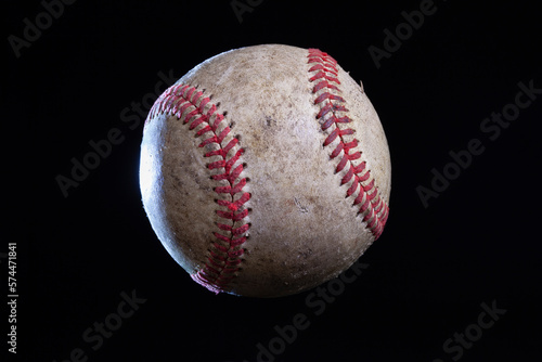 Old rough baseball with dramatic lighting isolated on a black background