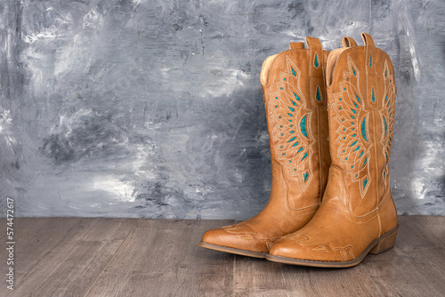 Cowboy boots  against a gray wall. Adventure and travel concept. photo
