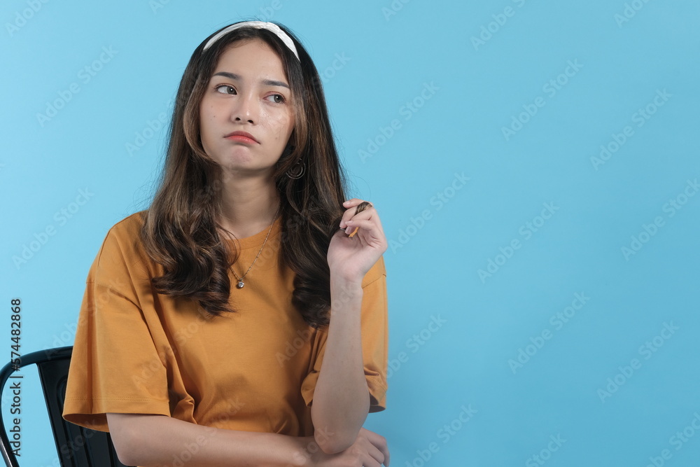 Asian young female getting resentful and angry isolated in blue background Asian young female getting resentful and angry isolated in blue background