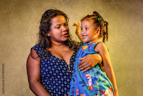 Braziliam mother and daughter hugging smiling for portrait mom and child, black or brunette