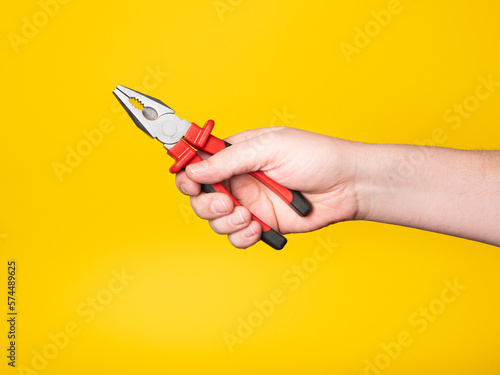 Canvastavla A hand holds a pair of pliers