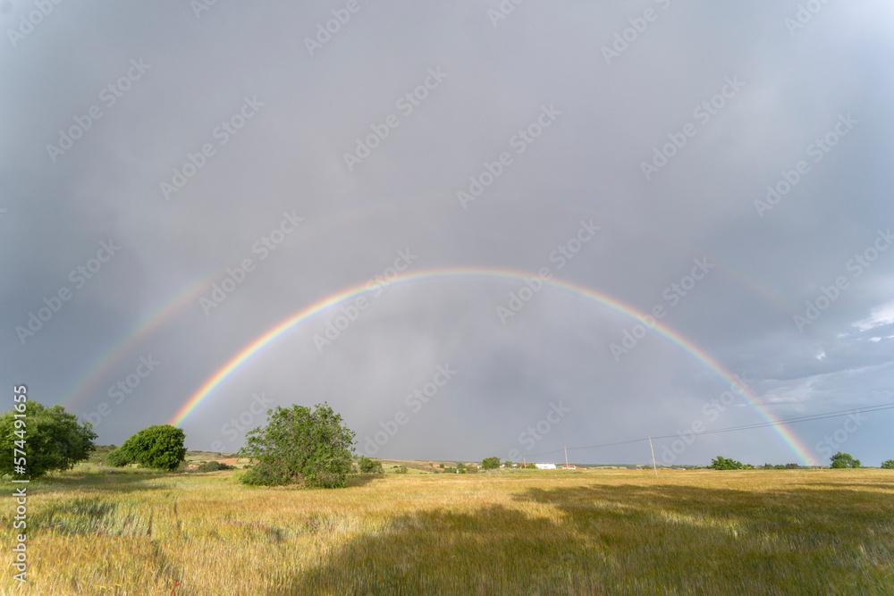 Summer yellowish field with a full rainbow in the background of the image. Torrejon del rey, Guadalajara. Spain Summer yellowish field with a full rainbow in the background of the image. Torrejon del rey, Guadalajara. Spain