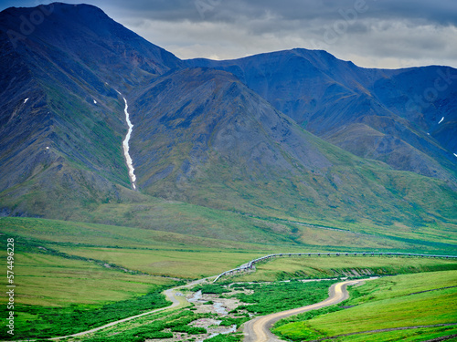 Summertime along the Dalton Highway North of the Coldfoot Camp on the road to Prudhoe Bay with the Alaska Pipeline dipping underground to protect the permafrost photo