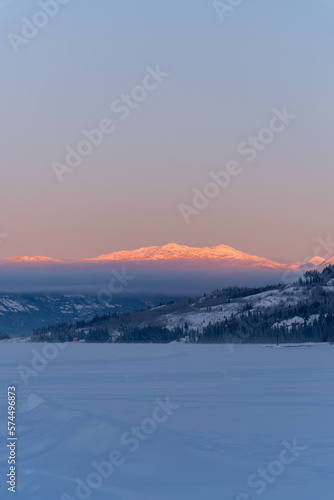 Incredible portrait view of winter landscape in Yukon Territory, Canada during sunrise with incredible pastel pink mountains. 