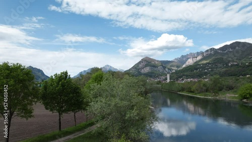 Aerial View Of Scenic Path Along River In Calolziocorte With Mountain Views In Background. Slow Dolly Ascending Shot photo