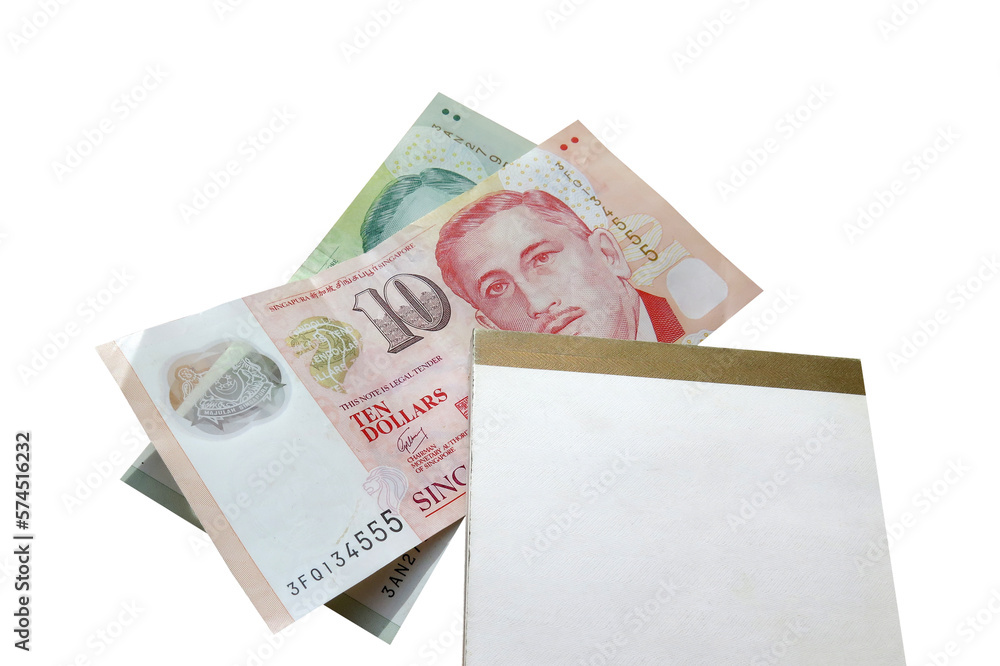 Notebook stacked on Singapore banknotes isolated on white Notebook stacked on Singapore banknotes isolated on white