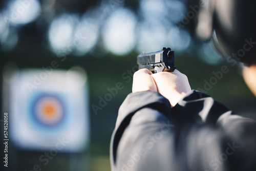 Fototapeta Naklejka Na Ścianę i Meble -  Gun, target and person training outdoor for shooting range, game exercise or sports event closeup. Hands with firearm and circle for aim, vision and practice, police learning academy or field gaming