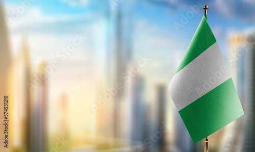 Slika na platnu Small flags of the Nigeria on an abstract blurry background