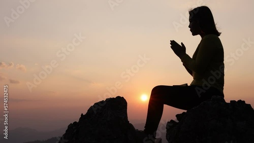  Video 4k  Slow motion,  Silhouette of woman Praying hands with faith in religion and belief in God On the morning sunrise background. Namaste or Namaskar hands gesture, Pay respect, Prayer position.