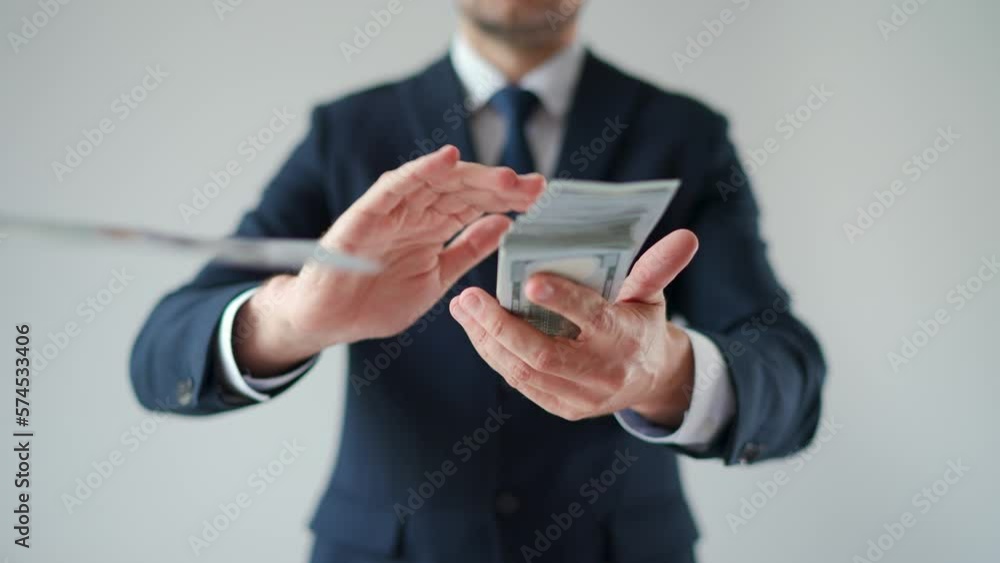 Formally dressed man makes money rain from US dollar bills. Slow motion. Formally dressed man makes money rain from US dollar bills. Slow motion.