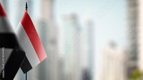 Small flags of the Yemen on an abstract blurry background