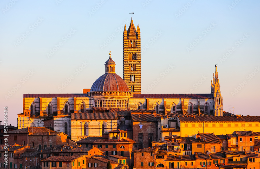 Bell Tower and Cathedral of Siena in Tuscany of Italy at sunset