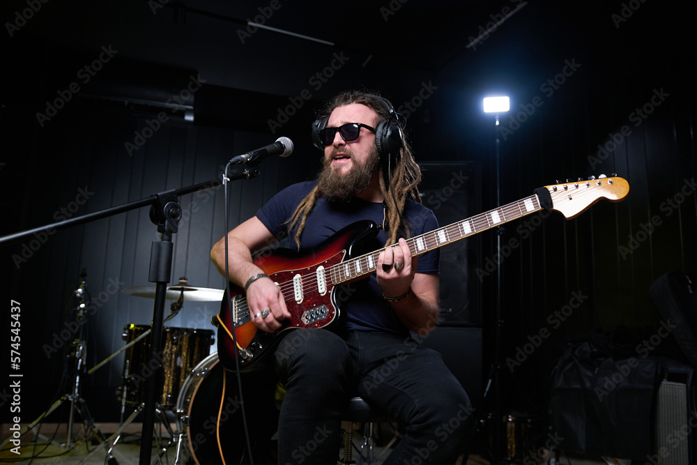 Obraz premium Guitarist man plays an electric guitar Close-up at studio