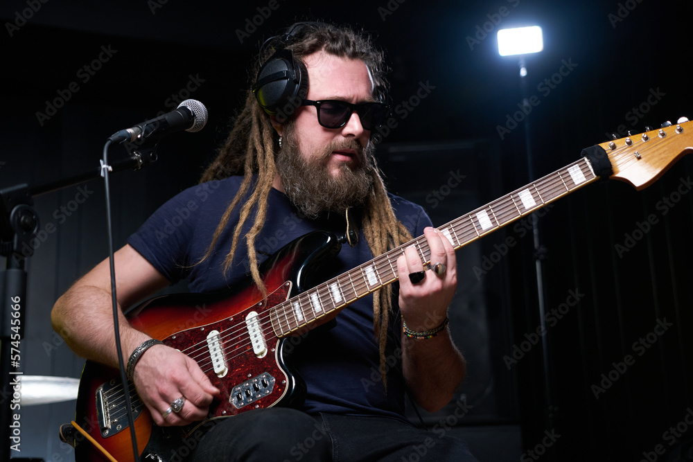 Obraz premium Guitarist man plays an electric guitar Close-up at studio