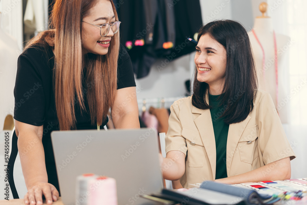 Happy beautiful Asia woman fashion designer clothes working with team in own dressmaking studio or boutique Happy beautiful Asia woman fashion designer clothes working with team in own dressmaking studio or boutique