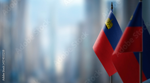 Small flags of the Liechtenstein on an abstract blurry background