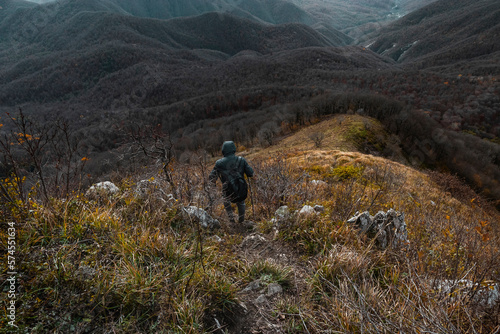A tourist with a backpack. Lifestyle travel, the concept of hiking. A man going hiking in the Caucasus mountains. with a heavy backpack. A traveler with a backpack on top of a mountain. 